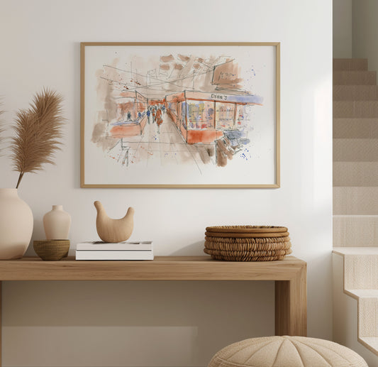 Jackie White's Market Sunderland watercolour artwork displayed in a frame on a wall, showing the busy market scene and characterful stalls, by Stephen Darling Art