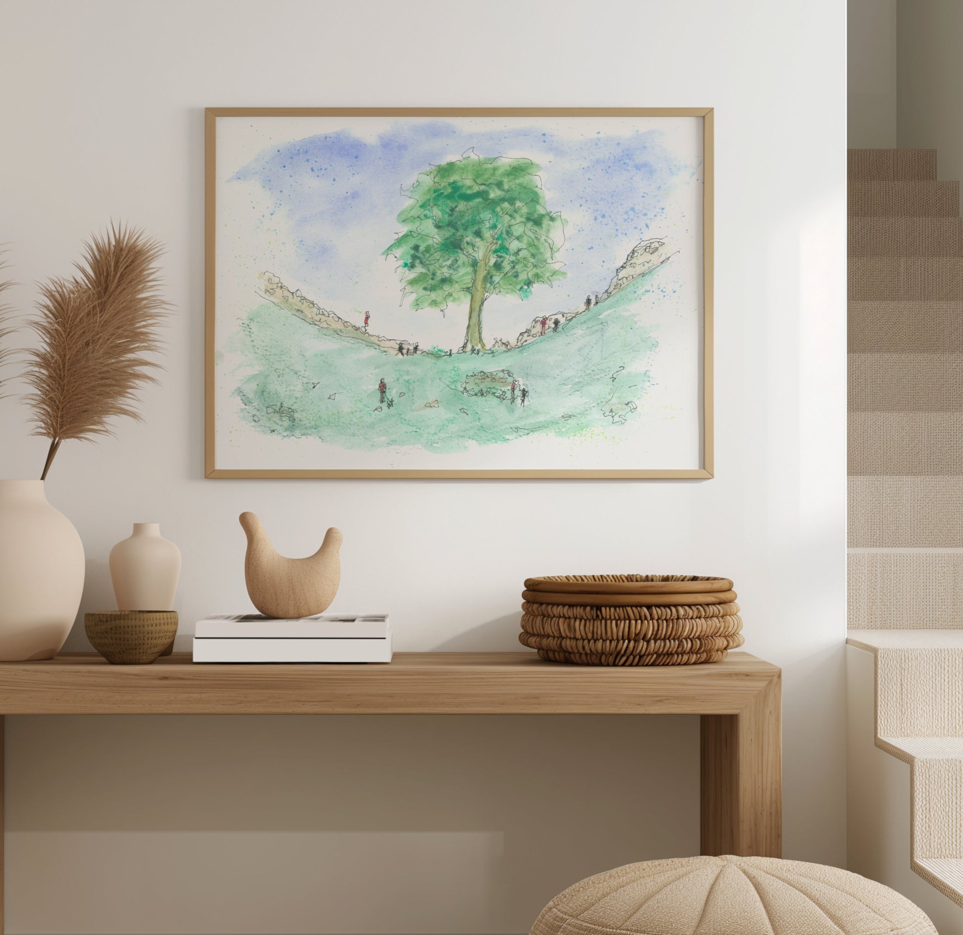Framed watercolour print of the Sycamore Gap Tree displayed on a wall, showing the rich colours and detail of the artwork in a home setting